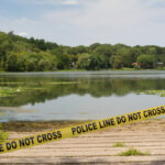 College Student Found Dead in Lake crime scene, police tape, police line, lake, investigation, shoreline, water, crime