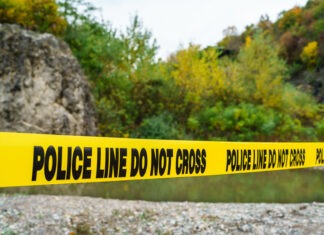 Missing Teen is Found Dead in River crime scene, police tape, police line do not cross, investigation, outdoor crime scene, law enforcement, yellow tape