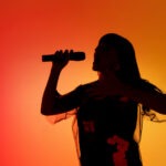 Legendary Singer Rushed to the Hospital singer, performer, concert, stage performance, microphone, live music, silhouette, entertainment