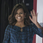 Michelle Obama Breaks Down With Candid Admission Michelle Obama, First Lady, waving, American flag, speaking event, political event