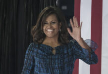 Michelle Obama Breaks Down With Candid Admission Michelle Obama, First Lady, waving, American flag, speaking event, political event