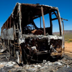 33 Killed, 18 Wounded in Bus Stop Bombing bus crash, burned vehicle, fire damage, crash site, vehicle wreckage, highway accident, desert road